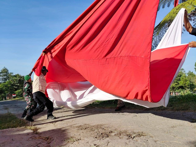 Bendera Merah Putih raksasa 9x6 meter berkibar di lereng Merapi, di Bukit Klangon, Kalurahan Glagaharjo, Kapanewon Cangkringan, Kabupaten Sleman, Jumat (16/8). Foto: Alfiansyah Panji