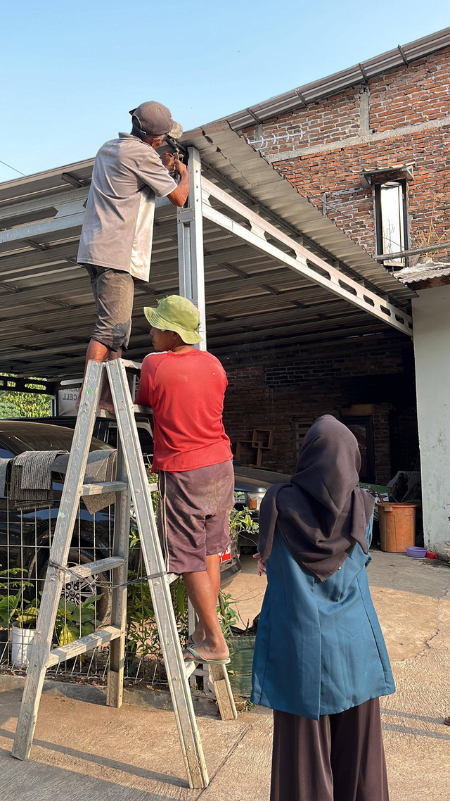 Proses Pemasangan Lampu Panel Surya Dibantu Oleh Beberapa Warga Setempat