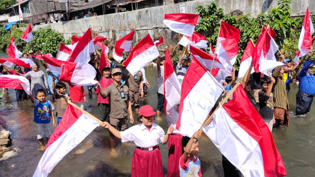 Warga mengibarkan 79 bendera merah putih di Kali Code, Sabtu (17/8/2024). Foto: Arfiansyah Panji/kumparan