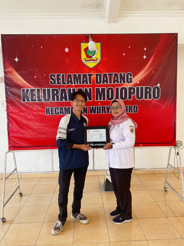 Penyerahan denah ruangan dan papan nama ruangan oleh Mahasiswa KKN kepada Ibu Kepala Kelurahan Mojopuro