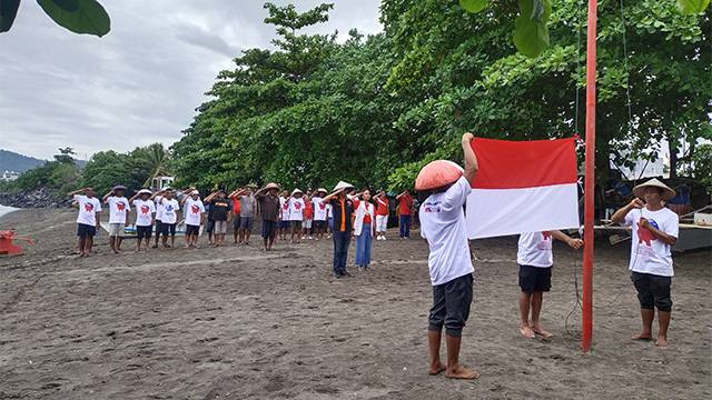 Warga pesisir dan nelayan Kota Manado, menggelar Upacara HUT RI di pantai Karangria Manado, Sabtu (17/8). Lokasi upacara ini masuk dalam wilayah yang akan direklamasi.