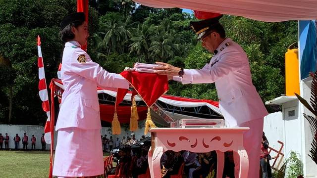 Penjabat Bupati Sitaro, Joi Eltiano B Oroh saat menyerahkan duplikat Bendera Pusaka pada upacara peringatan HUT ke-79 RI di Kabupaten Sitaro.