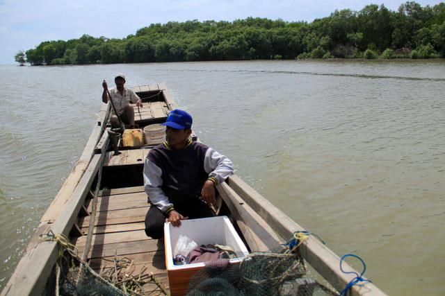 Perajin mengunakan sampan menuju pesisir untuk mengambil limbah ranting mangrove di pesisir Desa Tanjung Rejo, Deli Serdang. Foto: Yudi Manar/ ANTARA FOTO