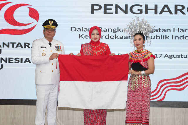 Margareta Mala saat menyerahkan Bendera Merah Putih dari kain tenun kepada Pj Gubernur dan Ketua Dekranasda Kalbar. Foto: Dok. Adpim Pemprov Kalbar