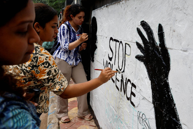 Petugas medis melukis slogan-slogan di dalam kampus Kolkata Medical College dan Rumah Sakit yang mengutuk pemerkosaan dan pembunuhan seorang dokter di sebuah rumah sakit di Kolkata, India, Senin (19/8/2024). Foto: Sahiba Chawdhary/REUTERS