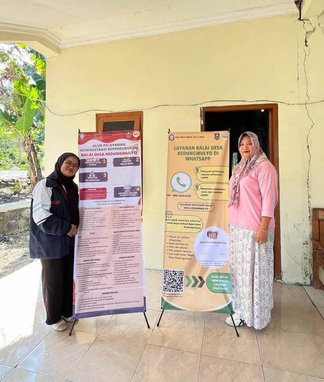 Penyerahan Standing Banner Oleh Adelia Ayu Rahmadina Putri Selaku Mahasiswa Tim II KKN UNDIP Kepada Sekretaris Desa Kedungmulyo (Sumber: Dokumentasi Pribadi)