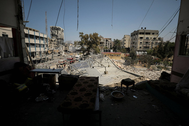 Warga Palestina memeriksa sekolah yang menampung pengungsi setelah terkena serangan udara Israel di Kota Gaza, Selasa (20/8/2024). Foto: Dawoud Abu Alkas/REUTERS