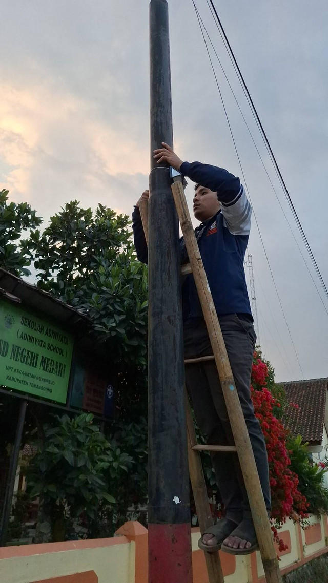 Mahahsiswa KKN Undip Memasang Lampu Penerangan Jalan Berbasis Lampu Tenaga Surya