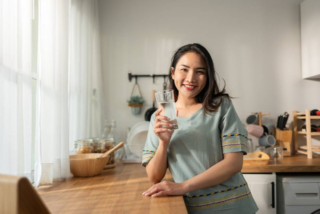 Ilustrasi perempuan minum air mineral. Foto: Shutterstock