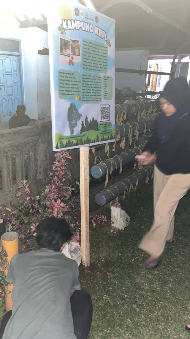 Proses Pemasangan Banner Infografis Kampung Tematik Desa Sumberdem