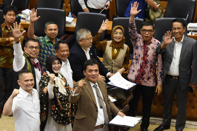 Menkumham Supratman Andi Agtas dan Mendari Tito Karnavian dan perwakilan fraksi yang menyetujui RUU Pilkada melambaikan tangan usai menandatangani naksah persetujuan dalam rapat pengambilan keputusan pembahasan RUU Pilkada di DPR RI, Rabu (21/8/2024) Foto: Indrianto Eko Suwarso/ANTARA FOTO