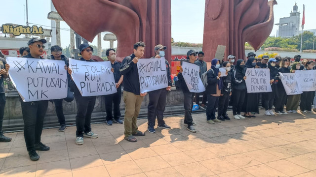 Sejumlah pengunjuk rasa kompak berbaju hitam menggelar aksi di depan Tugu Pahlawan, Surabaya, Kamis (22/8/2024). Foto: Farusma Okta Verdian/kumparan