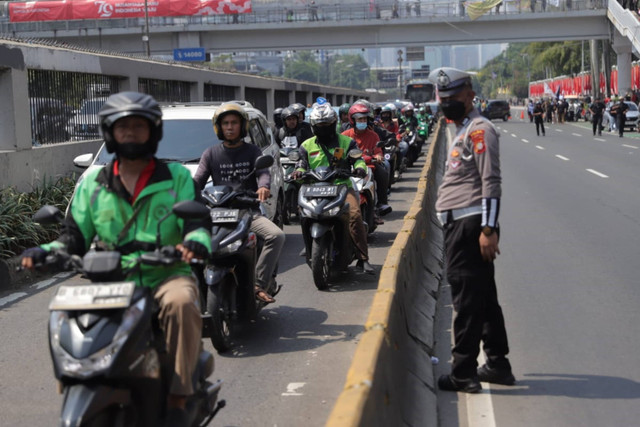 Sejumlah kendaraan melintas di jalur Busway saat aksi berlangsung di depan kompleks Parlemen, Senayan, Jakarta, Kamis (22/8/2024). Foto: Jamal Ramadhan/kumparan