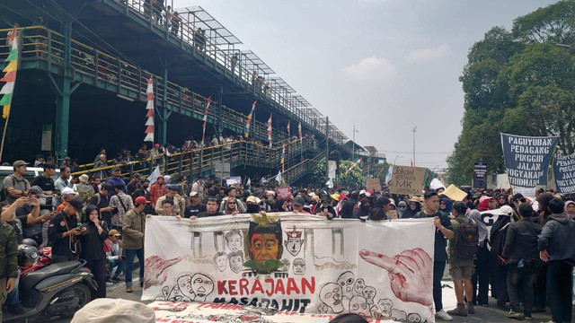 Massa aksi #KawalPutusanMK di Jogja membentangkan banner protes selama long march dari Parkiran Abu Bakar Ali menuju Kantor DPRD DIY pada Kamis (22/8) pukul 11.15 WIB. Foto: Iqbaltwq/Pandangan Jogja