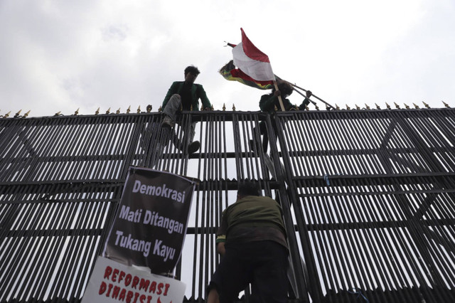 Sejumlah pengunjuk rasa membakar ban dan mencoba merusak serta memanjat gerbang Gedung Parlemen, Jakarata Pusat, Kamis (22/8/2024). Foto: Jamal Ramadhan/kumparan