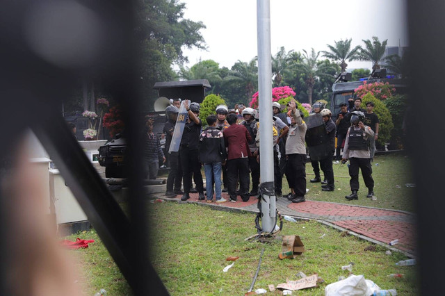 Massa masuk ke halaman DPR usai berhasil membobol pagar gedung DPR saat unjuk rasa RUU Pilkada, Kamis (22/8).  Foto: Jamal Ramadhan/kumparan