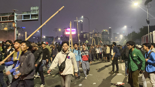 Pelajar datang ke area demo membawa bambu dan merusuh hingga polisi menembakan gas air mata di kawasan depan gerbang Gedung Parlemen, Jakarta, Kamis (22/8/2024). Foto: Abid Raihan/kumparan