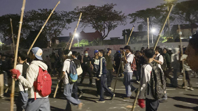 Pelajar datang ke area demo membawa bambu dan merusuh hingga polisi menembakan gas air mata di kawasan depan gerbang Gedung Parlemen, Jakarta, Kamis (22/8/2024). Foto: Abid Raihan/kumparan