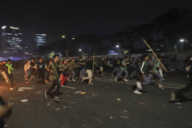 Demonstran berlari saat aparat menembakkan gas air mata di Jakarta, Kamis (22/8/2024). Foto: Jamal Ramadhan/kumparan