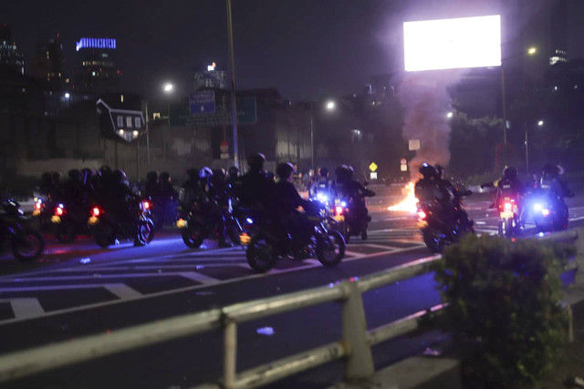 Aparat menggiring demonstran dengan motor trail di Jakarta, Kamis (22/8/2024). Foto: Jamal Ramadhan/kumparan