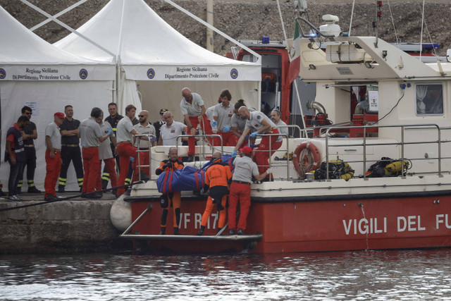 Petugas penyelamat mengangkat kantong mayat yang berisi jasad pengusaha Inggris Mike Lynch, yang tewas saat kapal pesiar milik keluarganya tenggelam di lepas pantai Porticello, dekat kota Palermo, Sisilia, Italia, Kamis (22/8/2024). Foto: Louiza Vradi/REUTERS