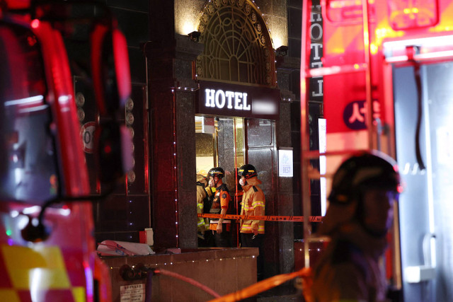 Petugas pemadam kebakaran di pintu masuk sebuah hotel setelah terjadi kebakaran, di Bucheon, di pinggiran kota Seoul, pada 22 Agustus 2024. Foto: YONHAP / AFP