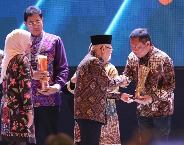 Wakil Presiden RI Ma’ruf Amin (tengah) didampingi Menteri Ketenagakerjaan RI Dr. Hj. Ida Fauziyah, M.Si (kiri) menyerahkan Penghargaan Nasional kepada Telkom dalam kategori BUMN yang Mempekerjakan Tenaga Kerja Penyandang Disabilitas dalam Naker Award 2024 yang diterima langsung oleh Direktur Utama Telkom Ririek Adriansyah (paling kanan) di JiExpo Kemayoran Jakarta, Jumat (23/8/2024). Foto: Dok. Telkom