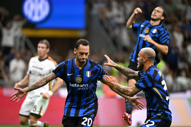 Hakan Calhanoglu berselebrasi dengan Federico Dimarco saat Inter Milan vs Lecce dalam laga pekan kedua Liga Italia 2024/25 di Stadion San Siro pada Minggu (25/8) dini hari WIB. Foto: REUTERS/Alberto Lingria