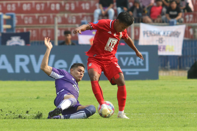 Pesepak bola Persik Kediri Ezra Harm Ruud Walian (kiri) berebut bola dengan pesepak bola Malut United FC Firman Ramadhan (kanan) pada pertandingan Liga 1 di Stadion Brawijaya, Kota Kediri, Jawa Timur, Minggu (25/8/2024). Foto: Prasetia Fauzani/Antara Foto