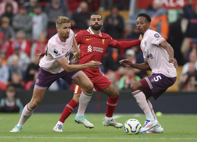 Mohamed Salah dari Liverpool beraksi dengan Kristoffer Ajer dan Ethan Pinnock dari Brentford pada pertandingan Liga Inggris antara Liverpool melawan Brentford di Stadion Anfield, Liverpool, Inggris, Minggu (25/8/2024). Foto: PHIL NOBLE/REUTERS