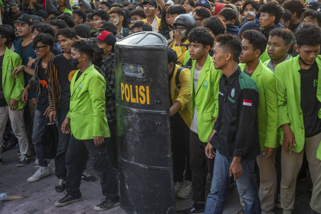 Seorang mahasiswa berlindung dengan tameng milik personel kepolisian saat unjuk rasa Gerakan Rakyat Jawa Tengah Menggugat (GERAM) di depan Kantor DPRD Kota Semarang, Kompleks Balai Kota Semarang, Jawa Tengah, Senin (26/8/2024). Foto: Aji Styawan/ANTARA FOTO 