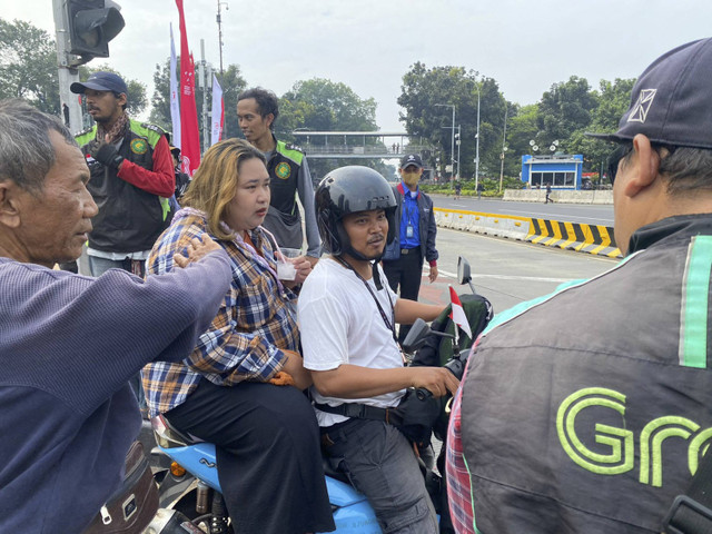 Seorang ojol dan penumpangnya diberhentikan massa aksi ketika melintasi kawasan demo di Patung Kuda, Jakarta Pusat  pada Kamis (29/8/2024). Foto: Abid Raihan/kumparan