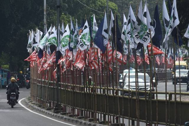 Pengendara melintas di dekat bendera parpol yang terpasang di pembatas jalan kawasan Tebet, Jakarta, Senin (17/7/2023).  Foto: Indrianto Eko Suwarso/ANTARA FOTO