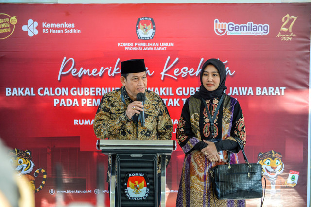 Pasangan bakal calon Gubernur Jawa Barat dan Wakil Gubernur Jawa Barat Acep Adang bersama Gitalis Dwi Natarina memberikan keterangan pers sebelum menjalani pemeriksaan kesehatan di Rumah Sakit Hasan Sadikin, Bandung, Jawa Barat, Jumat (31/8/2024). Foto: Raisan Al Farisi/ANTARA FOTO