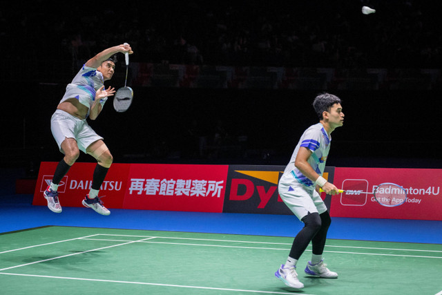 Leo Rolly Carnando dan Bagas Maulana dari Indonesia (kiri) melakukan pukulan pengembalian ke arah Goh Sze Fei dan Nur Izzuddin dari Malaysia dalam pertandingan semifinal ganda putra di hari kelima turnamen bulu tangkis Jepang Terbuka di Yokohama. Foto: YUICHI YAMAZAKI/AFP