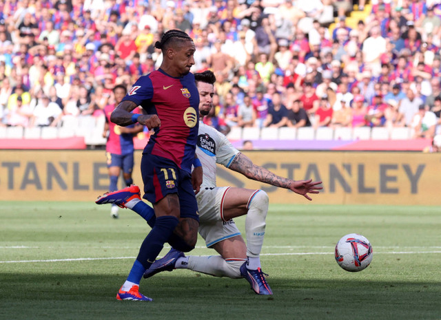 Raphinha dari FC Barcelona berusaha melwati pertahanan Luis Perez dari Real Valladolid. Foto: REUTERS/Bruna Casas