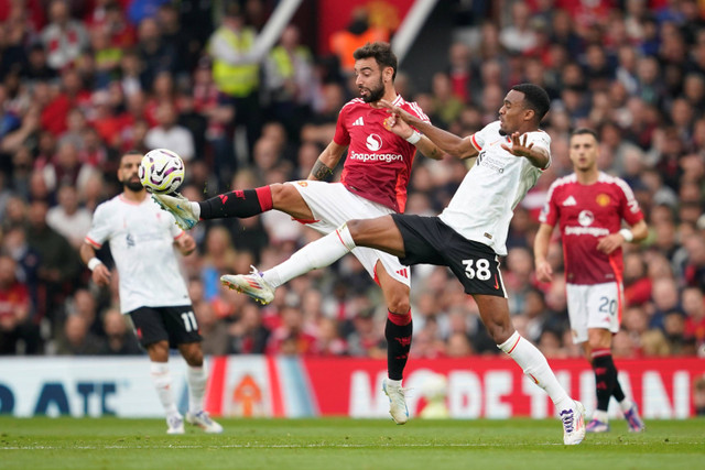 Pemain Manchester United Bruno Fernandes berebut bola dengan pemain Liverpool Ryan Gravenberch pada pertandingan Liga Inggris di Old Trafford, Manchester, Inggris, Minggu (1/9/2024). Foto: Dave Thompson/AP PHOTO