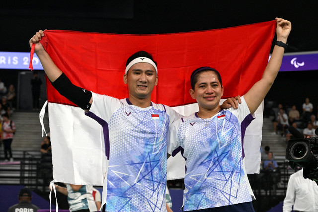 Ganda campuran Indonesia Ramdani Hikmat dan Leani Ratri merayakan kemenangan medali emas pada pertandingan Paralimpiade Paris 2024 di Porte de La Chapelle Arena, Paris, Prancis, Senin (2/9/2024). Foto: Jennifer Lorenzini/REUTERS 