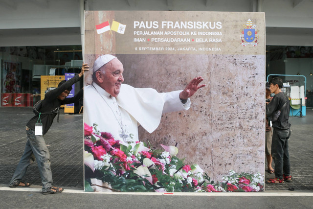 Pekerja mendorong papan reklame jelang misa akbar yang akan dipimpin oleh Paus Fransiskus di Kompleks Stadion Gelora Bung Karno, Jakarta, Selasa (3/9/2024). Foto: ADITYA AJI / AFP