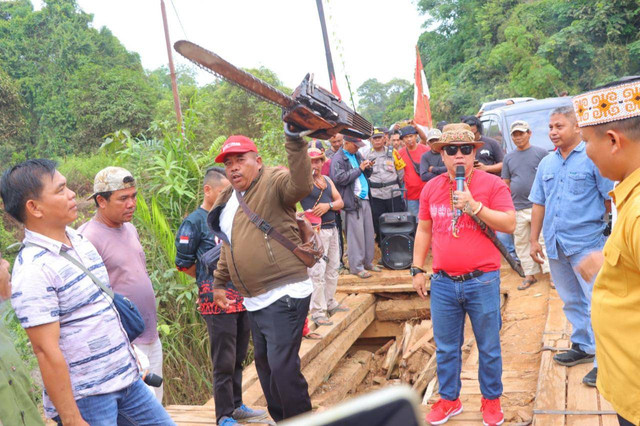 Aksi warga membawa gergaji mesin saat mendesak agar jembatan diperbaiki. Foto: Dok. Polres Sintang