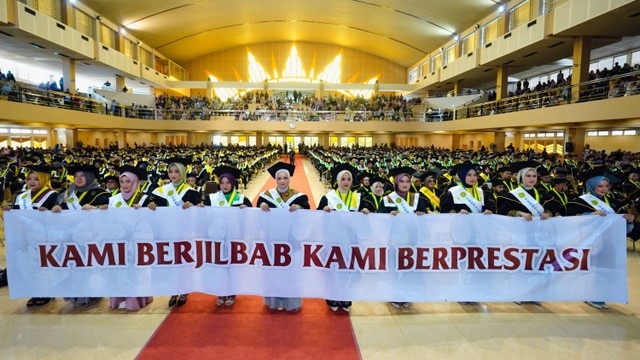 Spanduk "Kami Berjilbab Kami Berprestasi" dibentangkan wisudawati UMY pada Rabu (4/9).  Foto: Dok. UMY