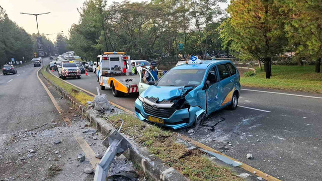 Petugas Jasamarga mengevakuasi mobil taksi no pol B.1091 WUC yang menabrak pembatas dan lampu penerangan jalan di pintu tol Pondok Aren, Tangerang Selatan, Kamis (5/9).  Foto: Aditia Noviansyah/kumparan