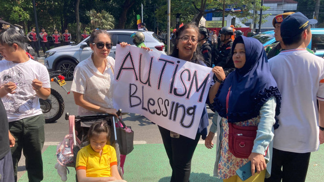 Jessica (38) menyambut kedatangan Paus dengan Banner "Autism Blessing" di Seberang Kantor KWI, Jakarta Pusat, Kamis (5/9). Foto: Alya Zahra/Kumparan