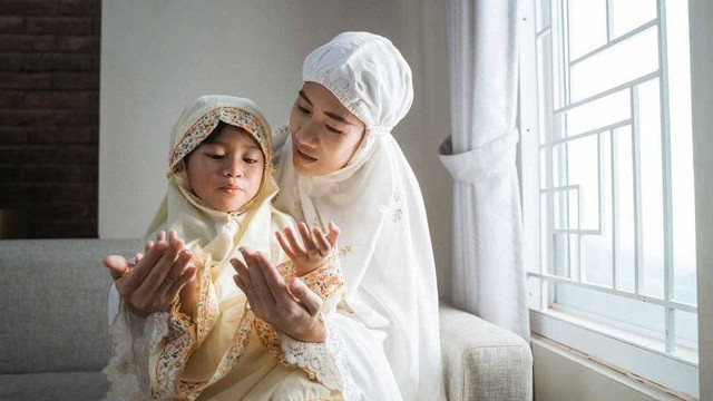 Ilustrasi Ibu yang mengajari anaknya sholat. foto/istock