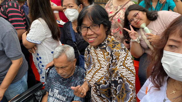 Yuliana yang mengantar suaminya, Johanes, untuk melihat Paus di kesempatan terakhir sebelum Paus pergi, di Kedubes Vatikan, Jakarta Pusat, pada Jumat (6/9/2024). Foto: Abid Raihan/kumparan