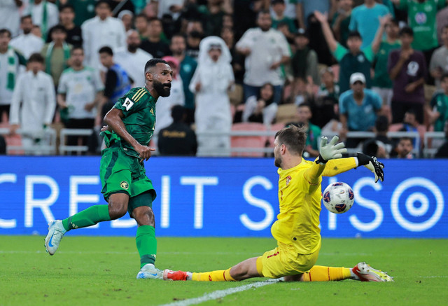 Penyerang Arab Saudi Feras Al Brikan berduel dengan penjaga gawang Indonesia Maarten Paes dalam pertandingan ronde tiga di King Abdullah Sports City, Jeddah, Arab Saudi, Jumat (6/8/2024). Foto: Stringer/Reuters