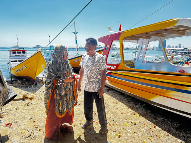 Mariyati Daeng Ngintang (kiri) bantu keuangan nelayan setelah menjadi AgenBRILink di Pulau Lae-lae Kec. Ujung Pandang, Kota Makassar. Foto: Dok. BRI