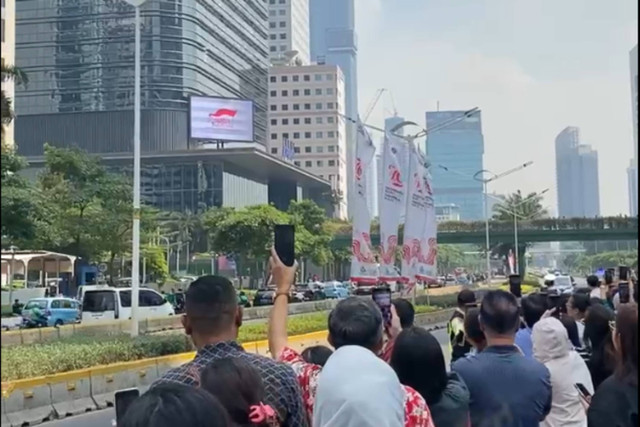 Sejumlah karyawan swasta menunggu kedatangan Paus Fransiskus melintas untuk pulang di Dukuh Atas, Jakarta, Jumat (6/9/2024). Foto: Clara Ajeng