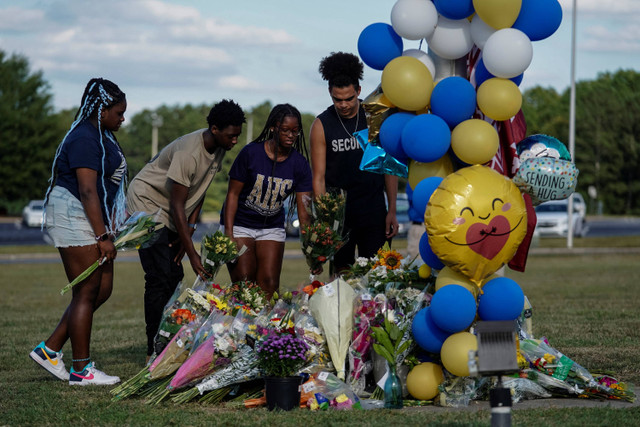 Orang-orang meletakkan bunga di lokasi peringatan sementara di Sekolah Menengah Atas Apalachee sehari setelah penembakan fatal yang menewaskan empat orang di Winder, Georgia, AS, 5 September 2024. Foto: Elijah Nouvelage/Reuters