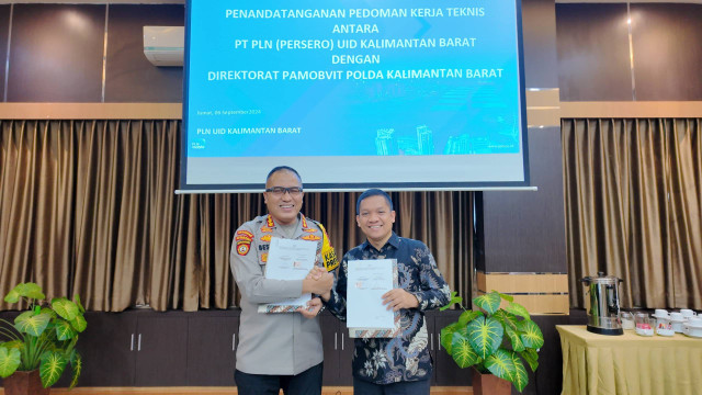 Dir. Pamobvit Polda Kalbar, Komisaris Besar Polisi Bestari H. Harahap, S.I.K., M.T. (kiri) dan Senior Manager Keuangan, Komunikasi dan Umum PLN UID Kalbar, Sapta Hidayat Nurdin (kanan) secara simbolis menyerahkan Pedoman Kerja Teknis (PKT). Foto: Dok. PLN Kalbar